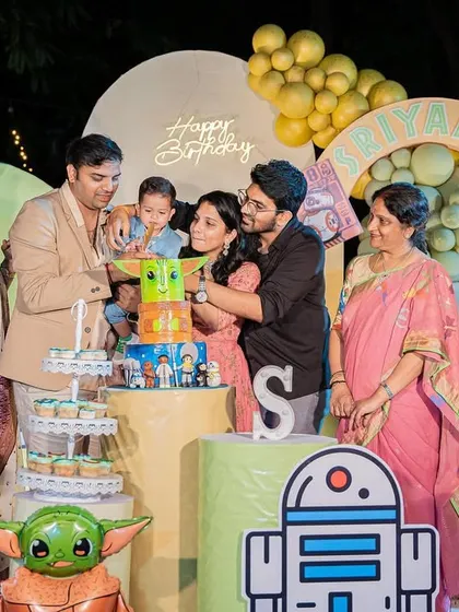 The whole family gathers for the cake cutting at the Star Wars-themed first birthday celebration.