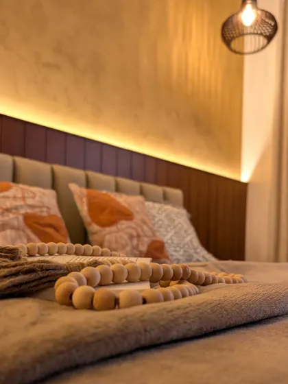 We focus on textures to create warmth, as seen here with the wooden beads, soft throws, and the upholstered headboard.