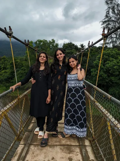 Three friends on the hanging bridge near the Netravathi trek base, a popular photo spot.