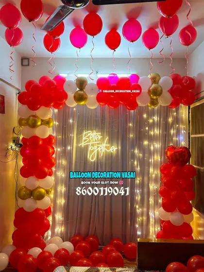 A focused look at the balloon arch and fairy light curtain from a romantic room decoration. The combination of red, white, and gold balloons creates a classic and festive atmosphere.