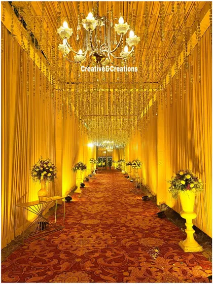 A stunning, high-contrast photo of the golden walkway. The deep red carpet and the brightly lit ceiling create a visually powerful and luxurious entrance.
