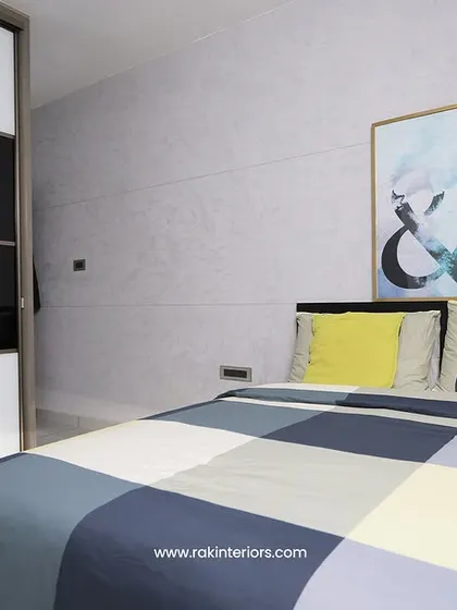 A modern bedroom with a black and white sliding wardrobe and a colorful checkered duvet.