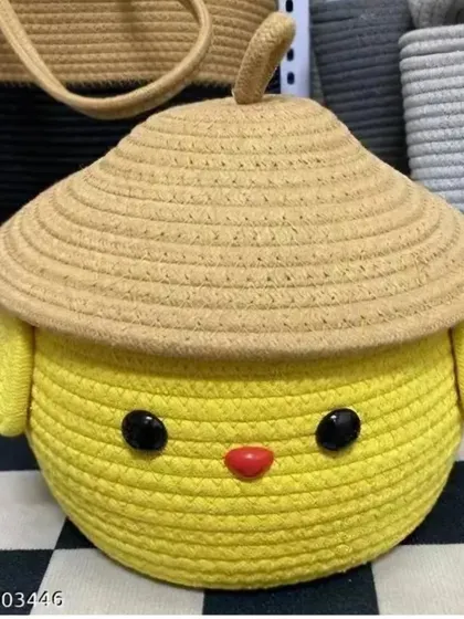 This yellow chick-themed rope basket with a straw-like hat is a unique and adorable storage piece, available for a flat price.
