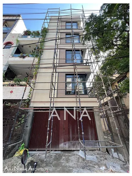The front facade of the Yellow Line Apartment under construction, just before the final gate installation. This view shows the building as a clean volume within the streetscape.
