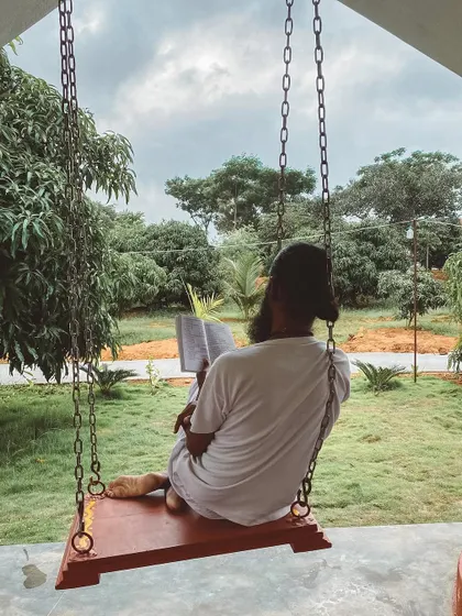 A student enjoys a quiet moment of reading on a swing. Life here moves at a slower pace, allowing you time for simple pleasures and personal reflection.