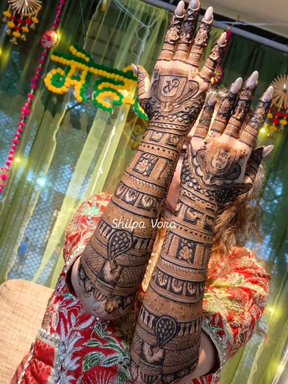 A stunning full-arm bridal mehndi for a client's big day. The design incorporates peacock motifs and personalized initials.
