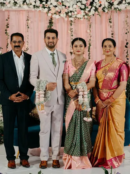 A lovely family portrait from Akarsh and Meghana's engagement at Talisva Winery. The floral backdrop, with its soft pink and white flowers, provided a beautiful setting for the couple and their loved ones.
