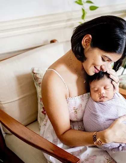 A mother's gentle touch. This intimate photo shows a new mum cradling her sleeping baby, wrapped snugly in a lavender swaddle. My newborn sessions focus on these quiet, loving connections.