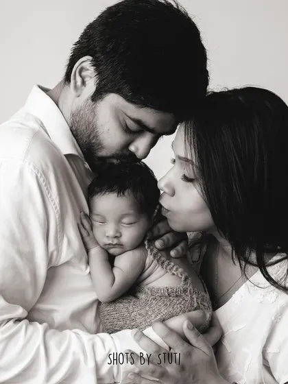 A black and white portrait of a new family, filled with love and tenderness.