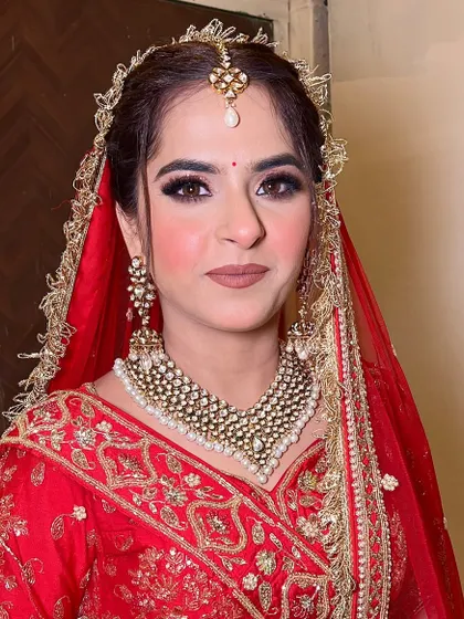 A close-up of this bride's classic look. The simple red bindi, winged eyeliner, and nude lipstick create a timeless and elegant aesthetic that never goes out of style.