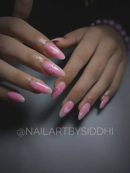A lovely set of pink "blossom" nails, featuring a jelly-pink base with subtle, hand-painted hearts and flowers.