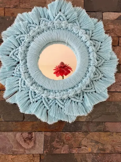 A beautiful macrame mirror in a soft pastel blue. These mirrors are a wonderful way to accentuate your walls and add a touch of handmade bohemian charm.