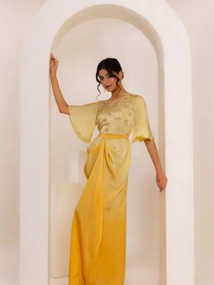 Another look from the A.Projekt campaign, this time a draped yellow midi dress. The styling against the arched, minimalist set was designed to highlight the garment's modern silhouette and delicate embroidery.