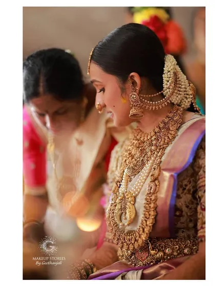 A beautiful moment between Vishnu Priya and her mother. Her profile shows the intricate details of her bridal hairstyle and the classic South Indian jewelry she wore.