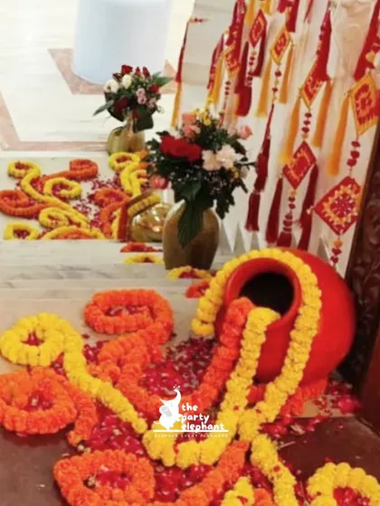 Traditional decor elements like these marigold garlands spilling out of a clay pot add an authentic and colorful touch to pre-wedding ceremonies.