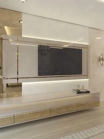 This luxurious TV unit uses reflective and marble-like surfaces to create a bright and glamorous feel. The long, low-profile console provides ample storage while maintaining a sleek, modern aesthetic.