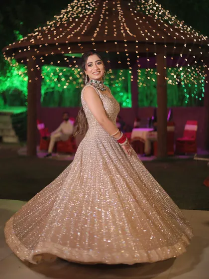A full-length shot of the bride twirling in her shimmery gown at her reception, set against a beautifully lit gazebo.