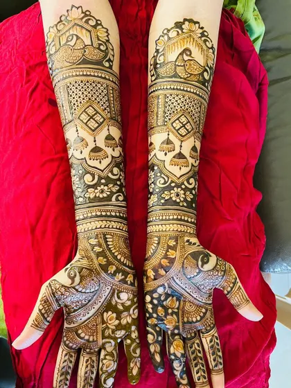 This design is a celebration of peacocks and jhumkas. These classic motifs are repeated throughout the hands and arms, creating a beautifully themed and traditional bridal mehendi.