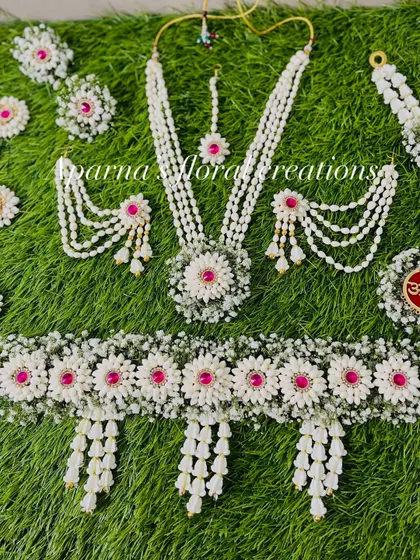 A full view of an intricate baby shower set. The kamarband is especially detailed, with multiple floral pendants made from fresh jasmine buds.