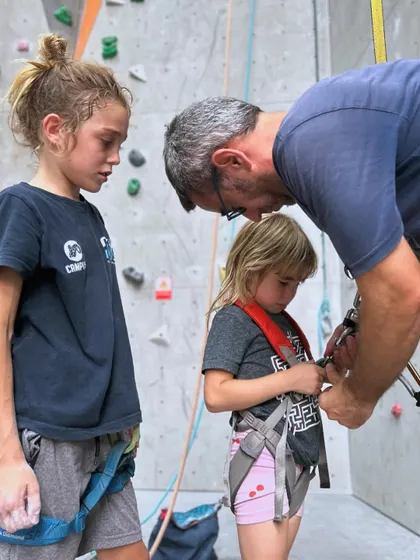 Safety first! A parent helps his two daughters get their harnesses fitted correctly before they start their climb. Our crew is always there to assist and double check gear.