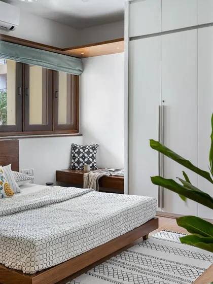This bedroom from our 'Pepper and Coffee' project includes a cozy window seat with built-in storage. The clean white wardrobes and wooden bed frame create a calm and uncluttered atmosphere.