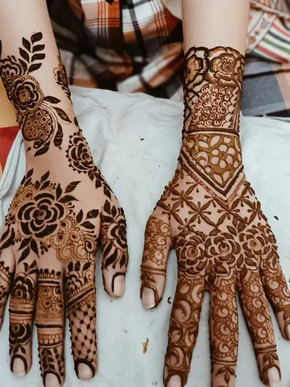 Here are two different hands, one with a bold Arabic floral vine and the other with a more geometric Indian pattern. This shows how I can create complementary yet distinct designs for groups.