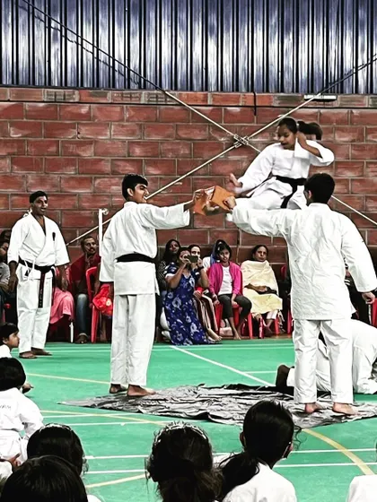 A black belt student executes a flying side kick to break a board during a demonstration. This showcases the spectacular and advanced skills that are achievable through our training syllabus.