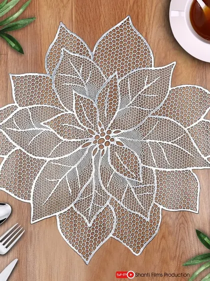A beautifully styled top-down shot of a lace table mat. We create complete scenes with props like cutlery and tea to help customers visualize the product in their own home.