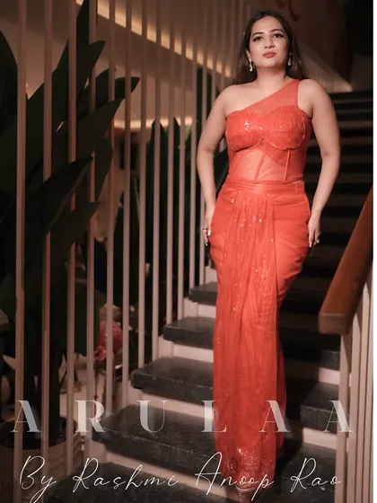 Another angle of the red-orange fusion gown. This view shows the sheer corset detailing and the elegant drape of the sequined skirt.