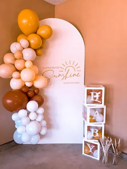A "Little Ray of Sunshine" baby shower setup with a single arched backdrop and "BABY" blocks. This is a great example of how I create beautiful aesthetics even in smaller spaces.