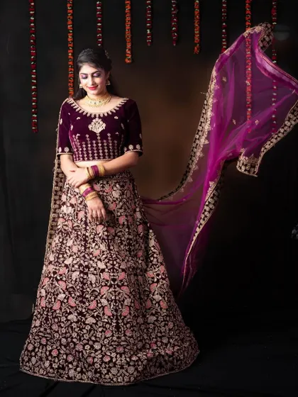 The flowing dupatta adds a touch of grace to this beautiful purple velvet lehenga.