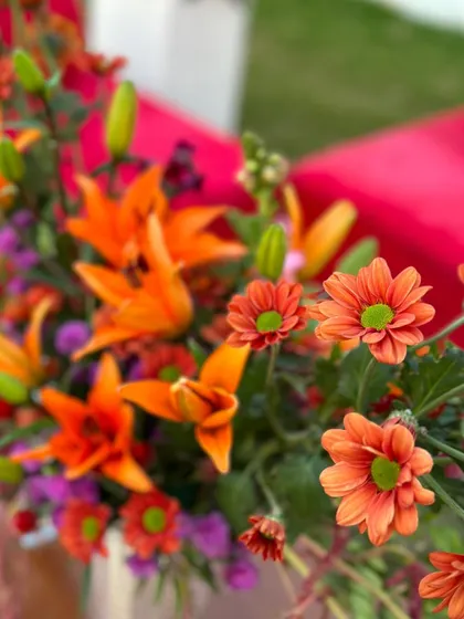 The bright, cheerful colors of orange lilies and chrysanthemums. Using fresh, high-quality flowers is essential for creating decor that feels alive and luxurious.