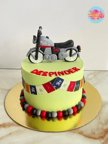 Another view of the Royal Enfield biker cake, showing the detail on the 3D fondant topper and prayer flags.