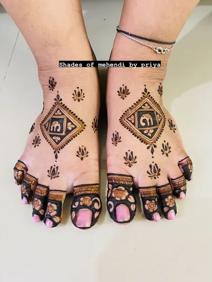 A minimalist foot mehendi design with a central diamond shape containing an elephant motif. The toes are decorated with simple floral caps.
