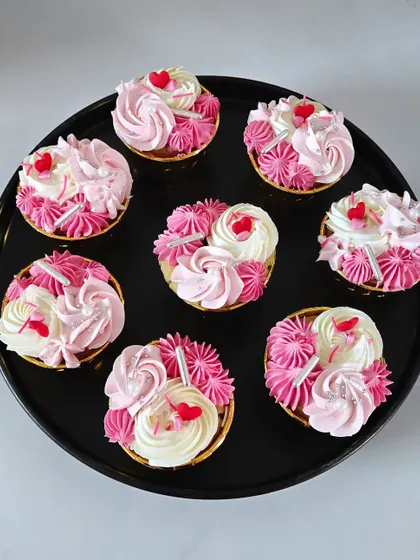 An overhead view of a batch of my vanilla and strawberry buttercream cupcakes, ready for a celebration. Each one is handcrafted and decorated with care.