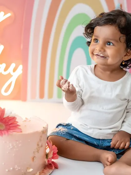 A happy smile after enjoying some delicious cake. The soft colors of the rainbow background complement her sweet expression.