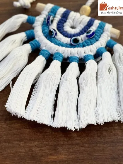 A detailed shot of the classic evil eye car charm, showing the texture of the macrame knots and the neatly combed tassels.