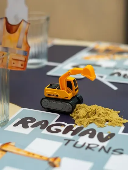 It's all in the details: a tiny construction vest drink charm and a miniature excavator with edible "dirt" on a personalized placemat.