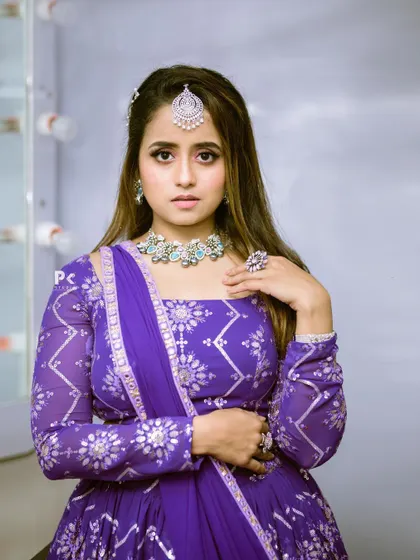 A close-up of the model in the purple and silver lehenga, highlighting the intricate print and matching jewelry.