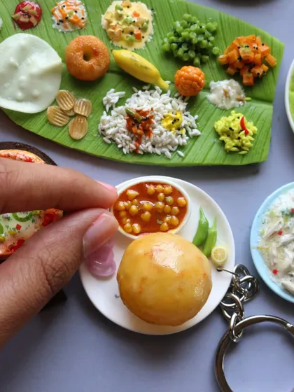 A close-up of a chole bhature keychain, showing the fluffy bhatura and the rich chole masala.