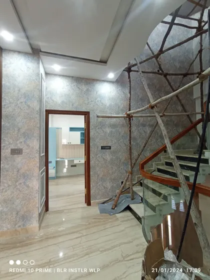 A textured wallpaper in a hallway, showing the installation in progress with scaffolding for the staircase.