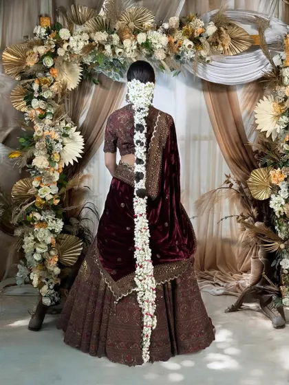 The back view highlights a breathtaking floral braid, cascading down the bride's back. This traditional jasmine 'gajra' hairstyle adds a fragrant and beautiful touch to the overall bridal look.