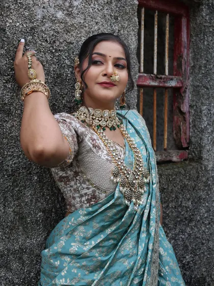 A confident pose against a rustic wall, showing the versatility of the blue Nauvari.