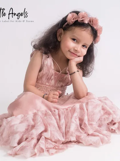 A soft and romantic dusty rose gown with a crushed fabric texture, perfect for a photoshoot.