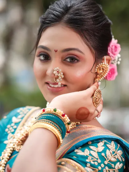 A close-up of the model's face, showing the intricate nath and ear cuffs.