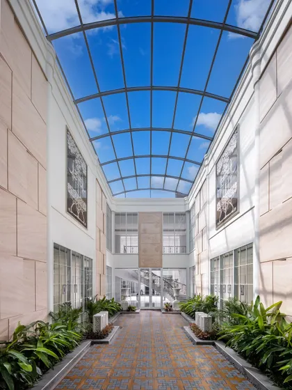 A central courtyard in The Grand Alabaster is covered by a vast glass skylight, bathing the space in natural light. This feature creates an indoor garden that feels open to the sky, blending architecture with nature.