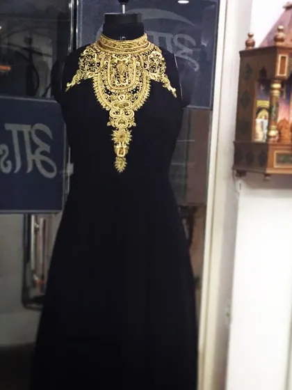 I love creating bold, statement pieces like this black evening gown. It combines a modern, high-neck silhouette with traditional, heavy gold zari and dabka embroidery, creating a stunning Indo-Western look that is sure to turn heads.