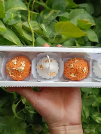 A perfect festive gift set, this box contains two laddoo candles and three modak candles, all decorated with gold leaf. It's a unique twist on traditional sweets.