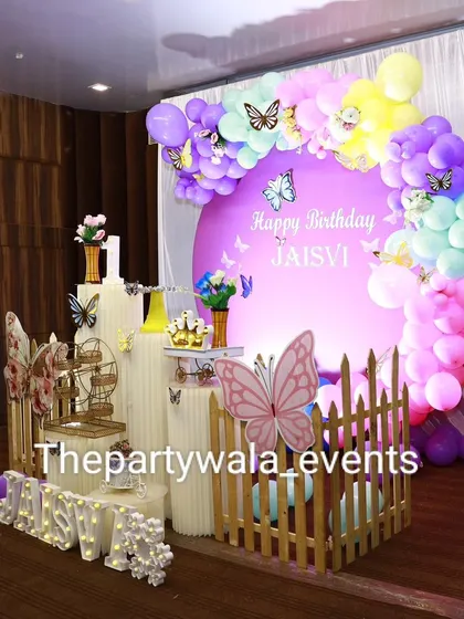A colorful butterfly theme with a purple backdrop and a rainbow of balloons.