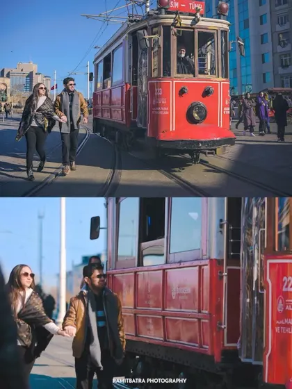 A couple walks hand-in-hand alongside the iconic red tram on Istiklal Avenue in Istanbul, Turkey.